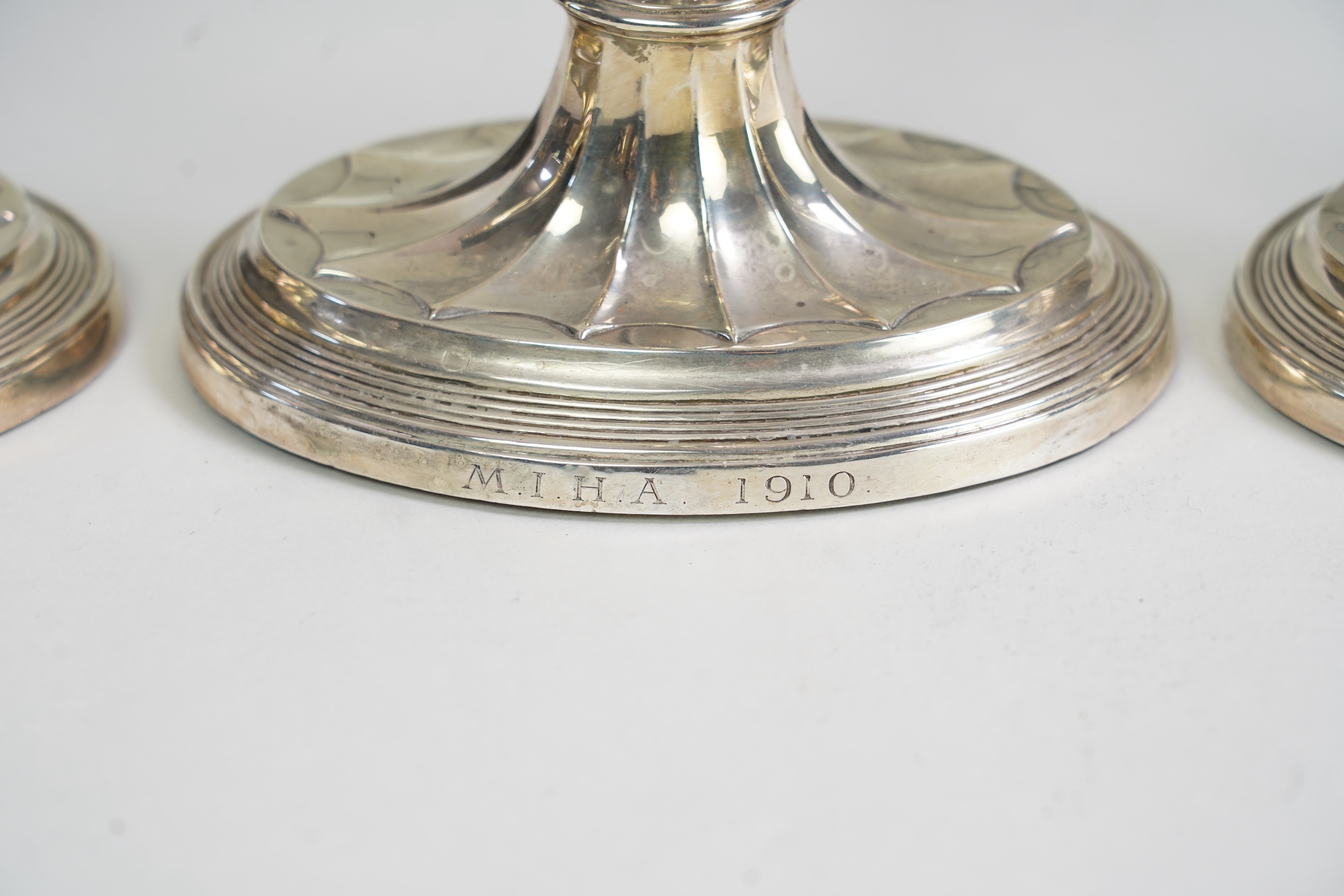 A matched set of four Edwardian fluted silver candlesticks, by Sibray, Hall & Co Ltd